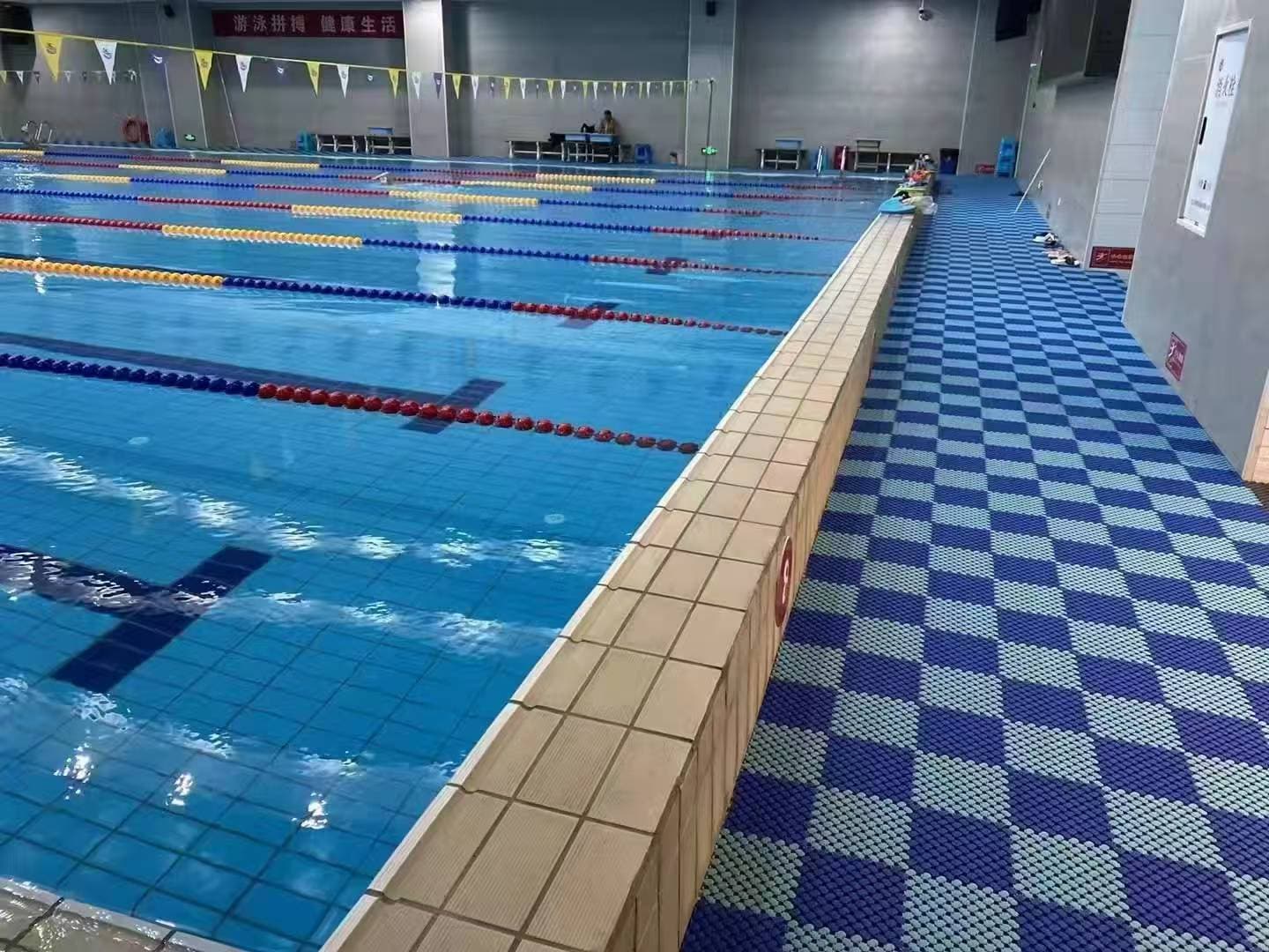 Perímetro de piscina con patrón azul de piso drenante modular