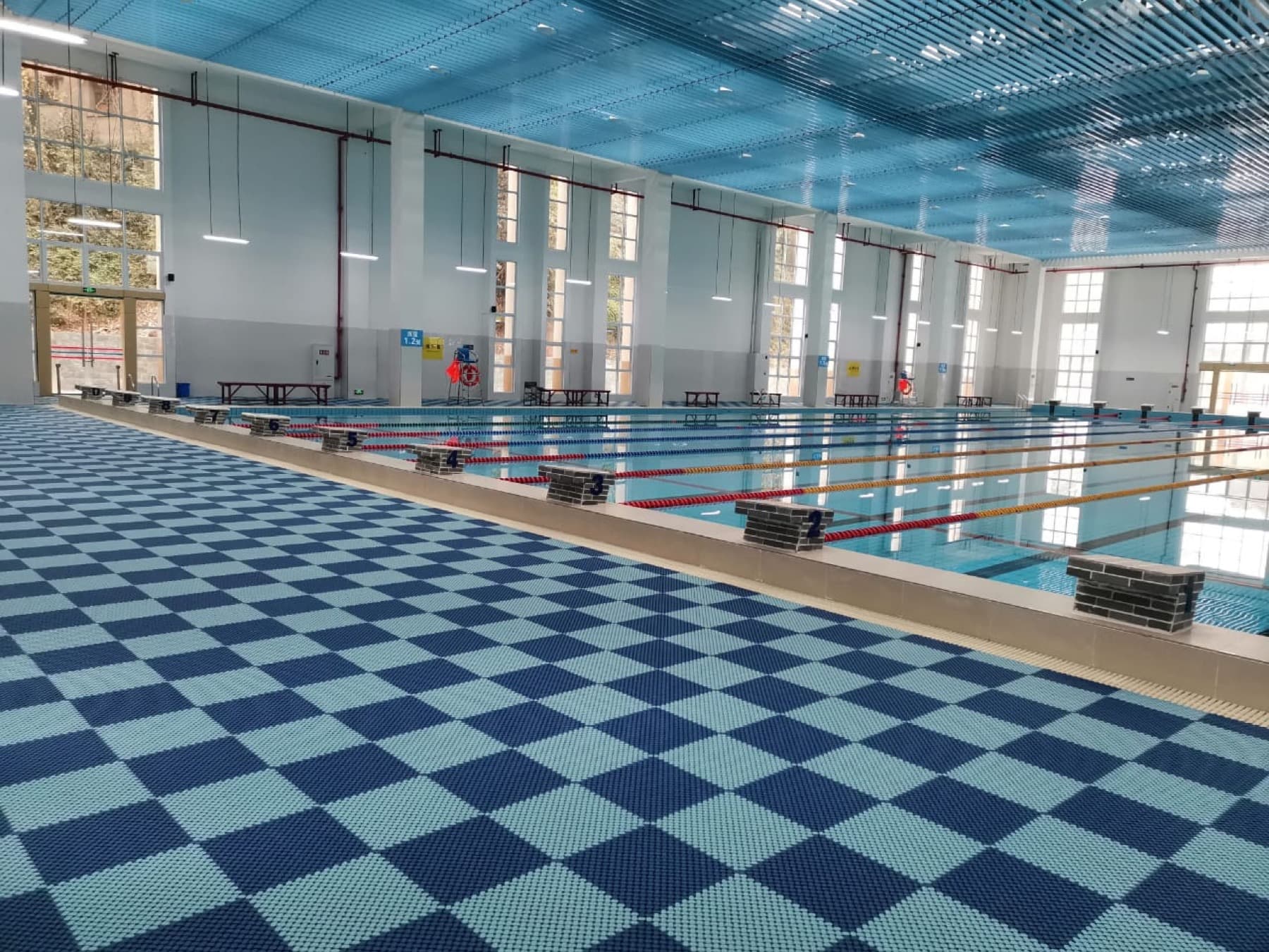 Piso modular antideslizante ATLOS en el borde de una piscina cubierta